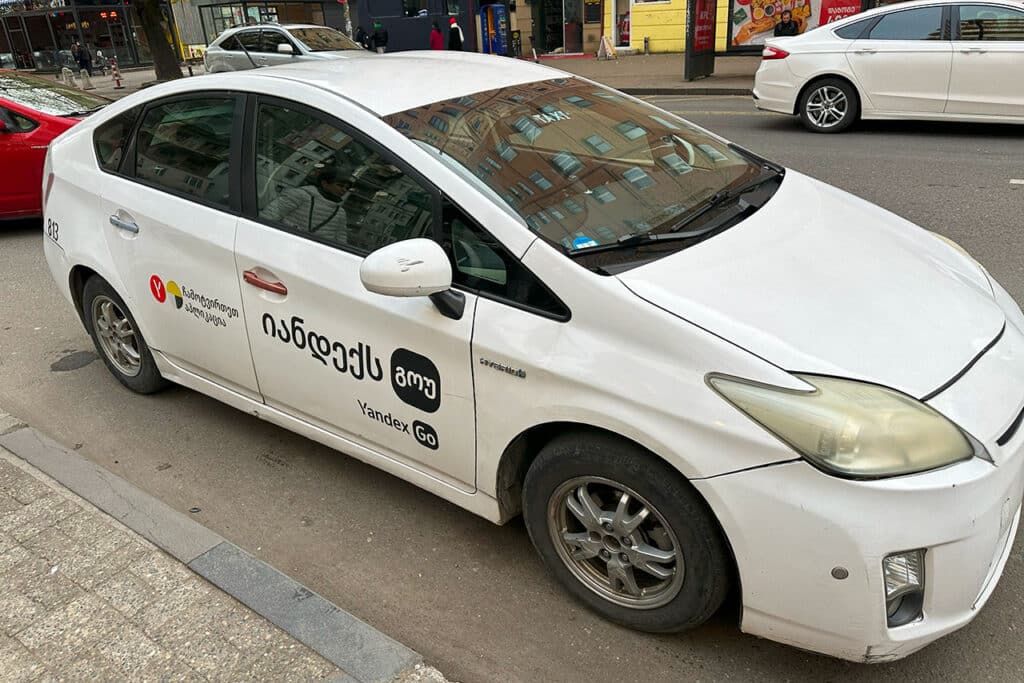 Машина с логотипом Яндекс Такси на улицах Грузии