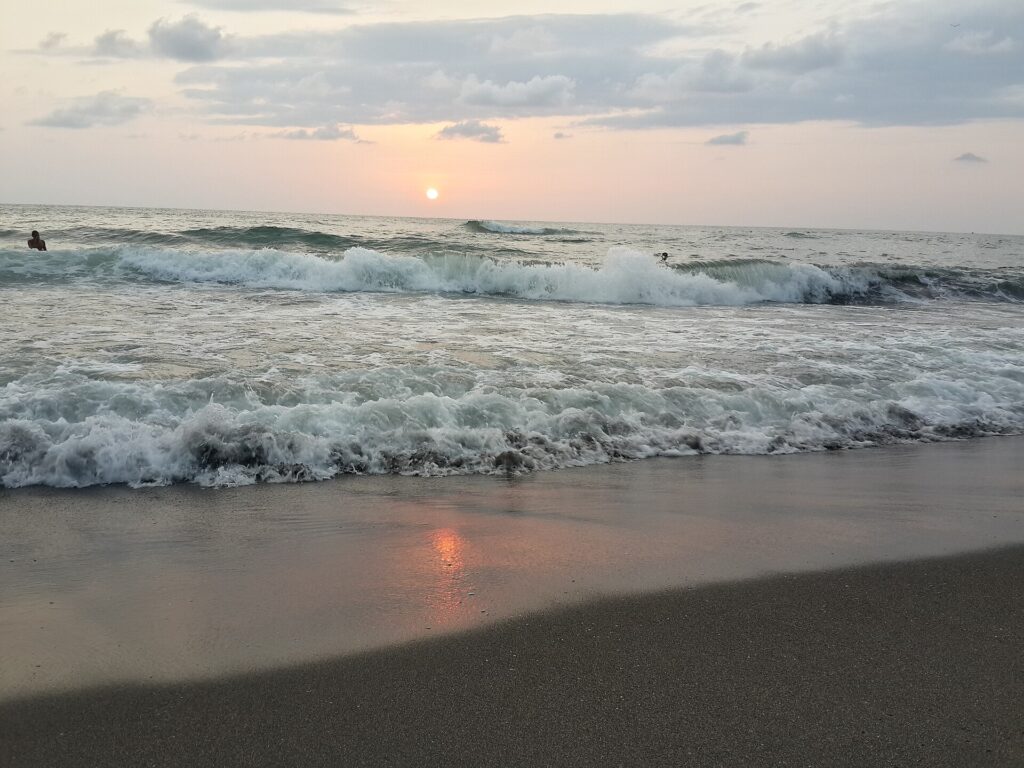 Black magnetic sand of Ureki beach at sunset